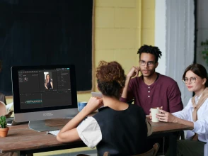 Woman presenting a social media marketing strategy to a team in a modern meeting room.