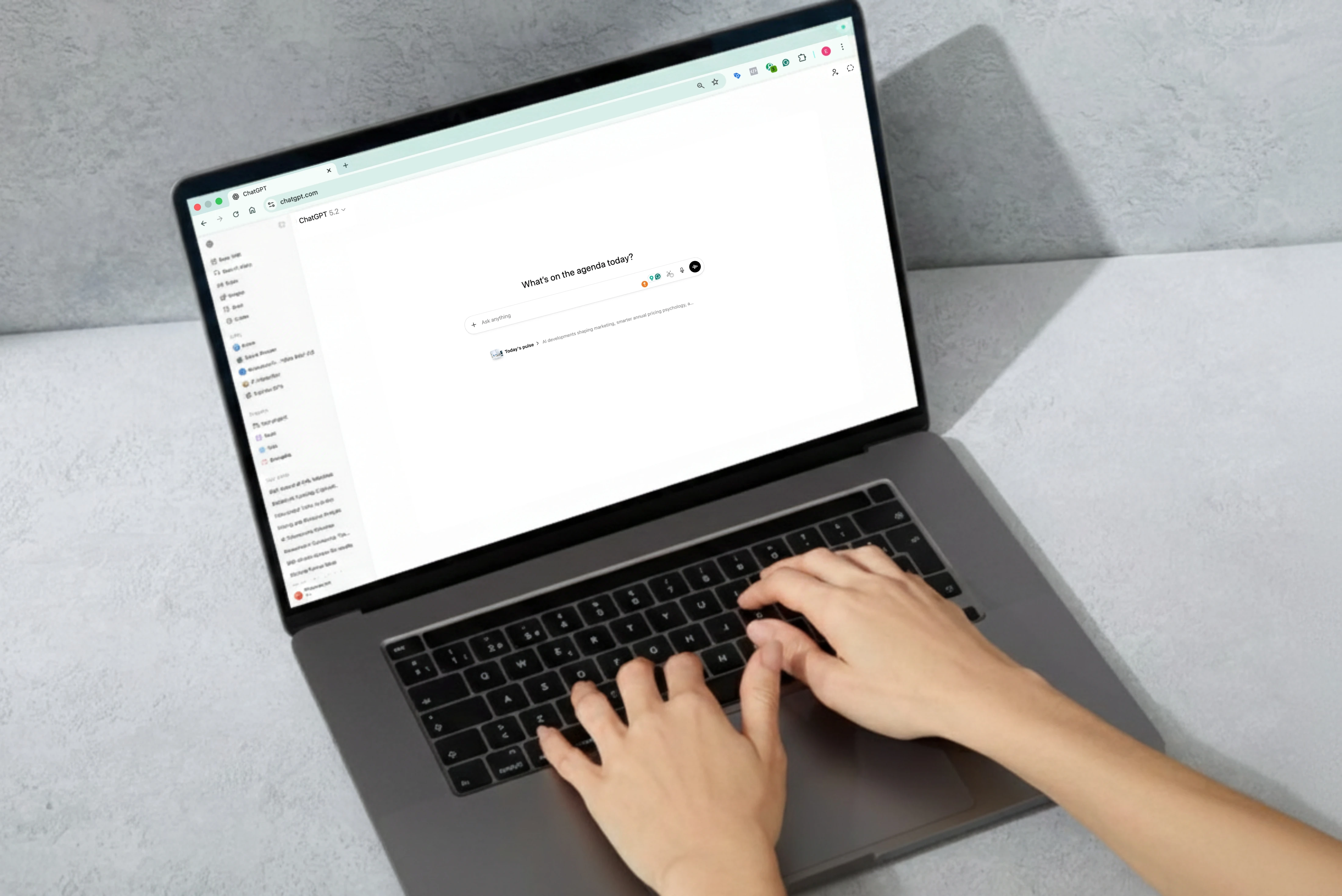 Person typing on a laptop using the ChatGPT interface on screen.