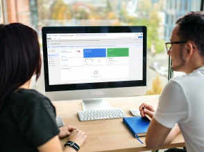 Two professionals reviewing Google Tag Manager setup on a desktop computer.