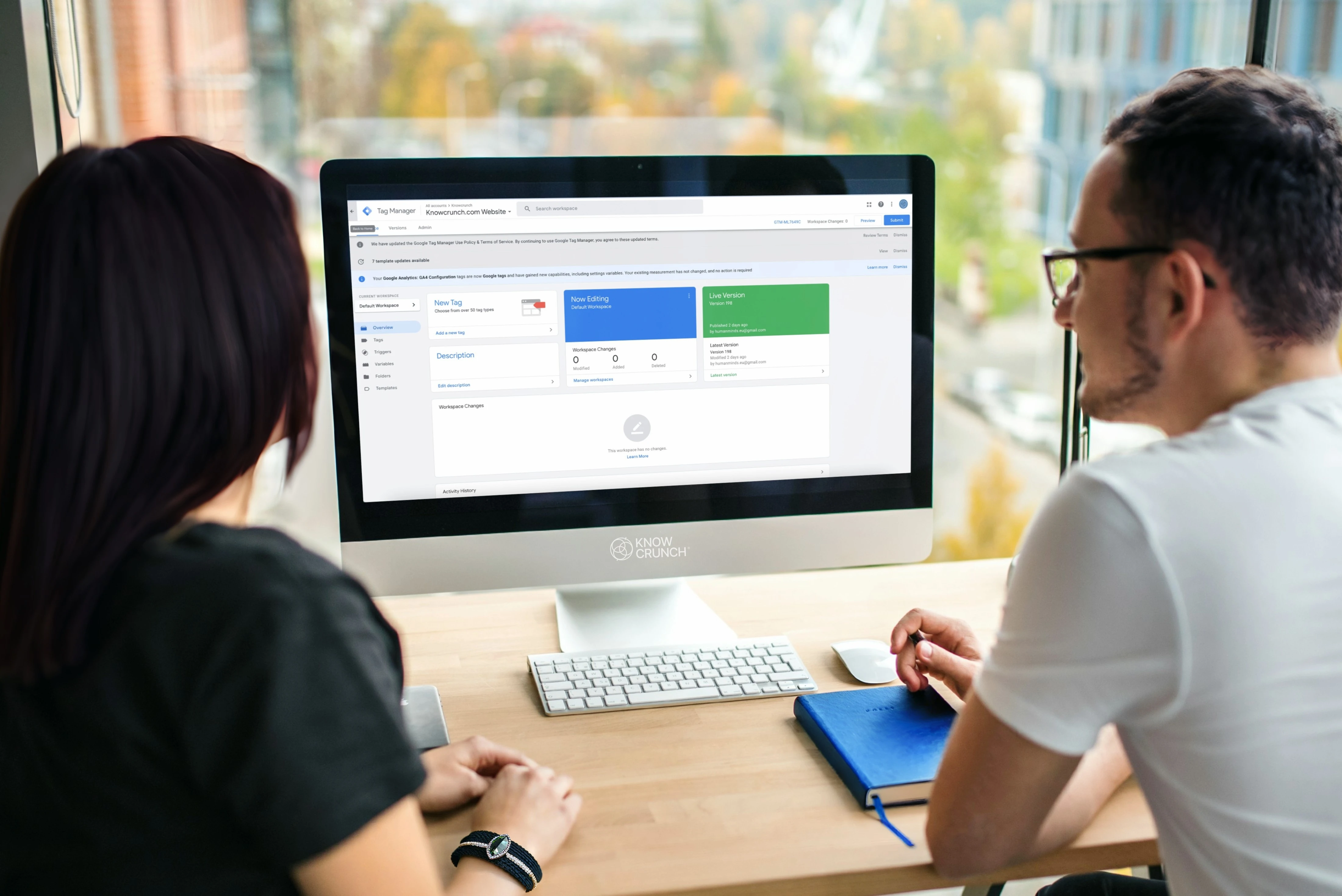 Two professionals reviewing Google Tag Manager setup on a desktop computer.
