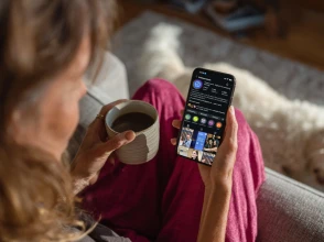 Person browsing the Knowcrunch Instagram profile on a smartphone while relaxing at home.