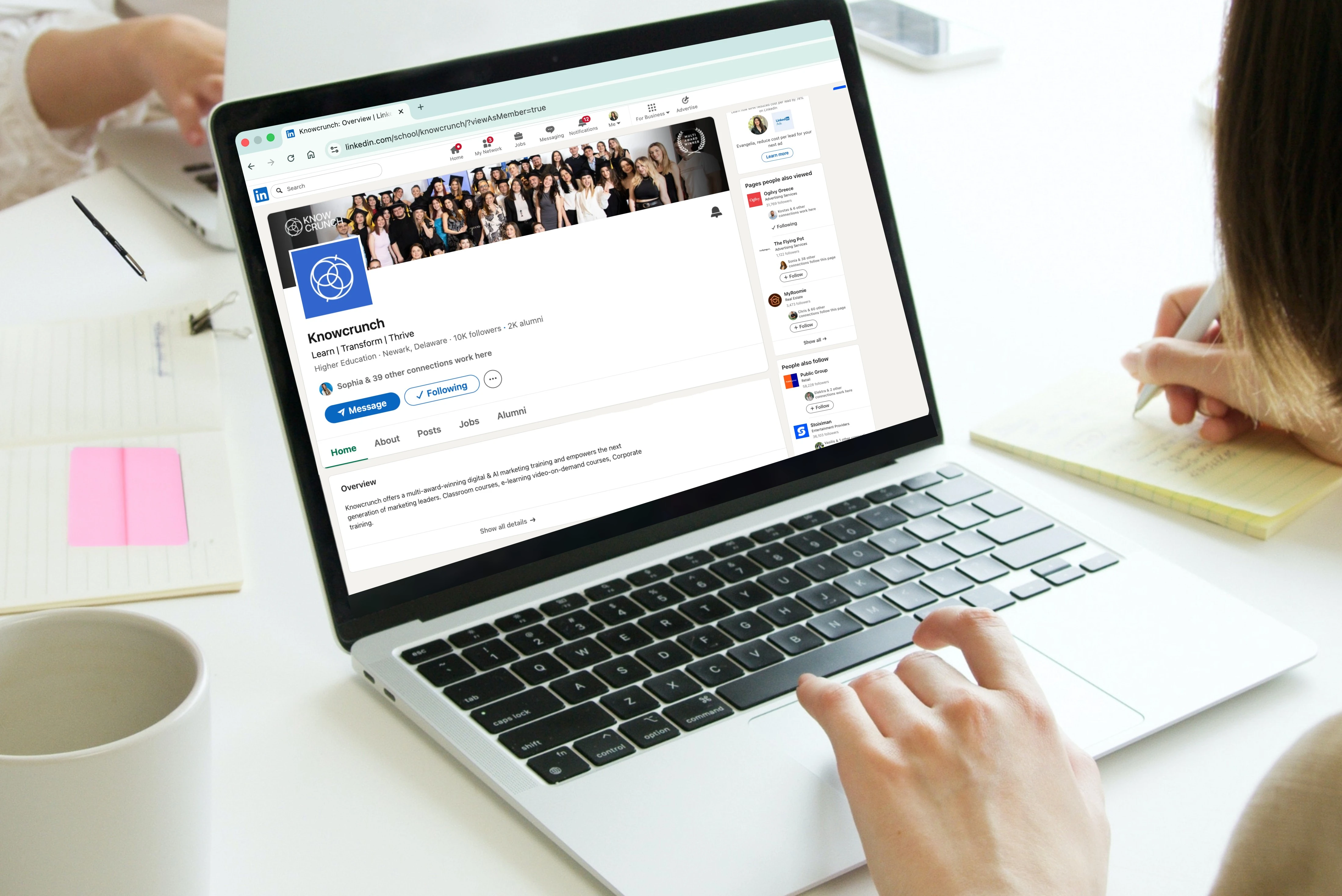 Person managing a Knowcrunch LinkedIn company page on a laptop at a desk.