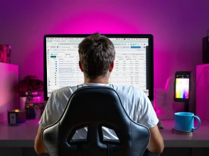 Person working on Meta Ads Manager campaigns on a large desktop screen in a home office.