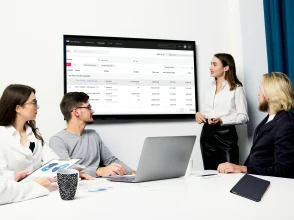 Instructor presenting TikTok advertising campaign results to a team in a meeting room.