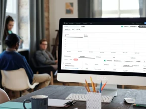 Woman presenting a social media marketing strategy to a team in a modern meeting room.